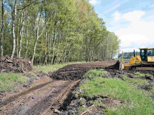 Raupenfahrzeuge bewegten 10.000 m3 Verfüllmaterial, um den Ringgraben dem Erdreich gleich zu machen. Foto: Wolfgang Bellwinkel/laif