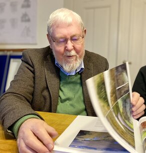 Michael Succow beim Durchblättern des Moorbuches.